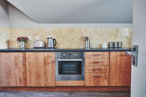 uma cozinha com armários de madeira e um fogão em Garrison Apartments em Fort William
