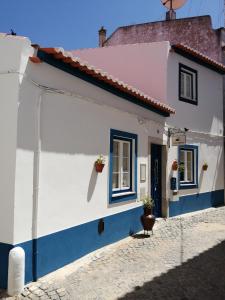 uma casa branca e azul com duas janelas em Maria`s Guesthouse em Beja