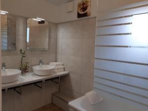 La salle de bains est pourvue de 2 lavabos et d'un miroir. dans l'établissement Aerotel Versailles Saint Cyr - L'étape du Silence, à Saint-Cyr-lʼÉcole