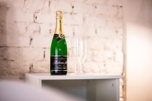 a bottle of champagne sitting next to a wine glass at Penzion Papírna in Cheb