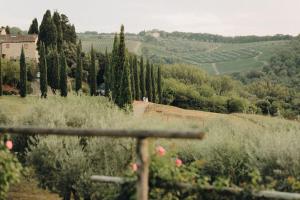 Blick auf ein Feld mit Bäumen und ein Gebäude in der Unterkunft Tenuta Sant'Ilario in Gambassi Terme