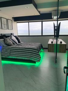 a bedroom with a bed with green lights on the floor at Presidential Suite na orla da Praia da Costa in Vila Velha +29 photos