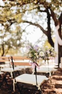 - un bouquet de chaises avec un bouquet de fleurs dans l'établissement Tenuta Sant'Ilario, à Gambassi Terme