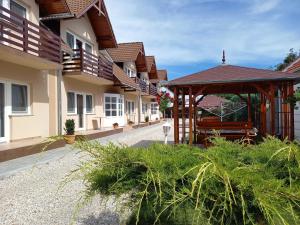 a building with a gazebo next to a street at Petrovics Apartmanház 1 in Bük