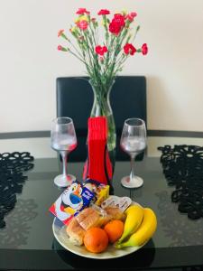 a plate of food on a table with wine glasses and flowers at Private Apartment in Dumfries