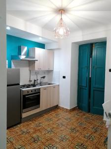 een keuken met een fornuis en een blauwe deur bij CasaCasetta Suite Appartamento Indipendente in Taranto