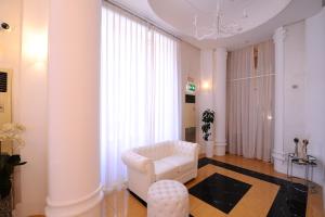 un soggiorno con sedia bianca e sgabello di Artemisia Palace Hotel a Palermo