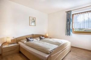 a bedroom with a bed and a window at Haus Belodei - Apt B in San Martino in Badia