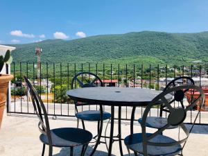 a table and chairs with a view of a mountain at Hotel Carretas by Rotamundos in Jalpan