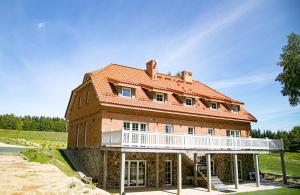 ein großes Backsteinhaus mit einem Balkon an der Seite in der Unterkunft Przystań Piecek in Stręgielek