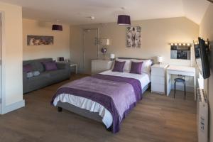 a bedroom with a bed and a couch at Isabella House - Hereford City Centre Aparthotel, By RentMyHouse in Hereford