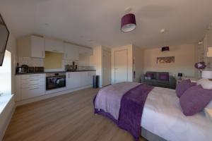 a large bedroom with a large bed and a kitchen at Isabella House - Hereford City Centre Aparthotel, By RentMyHouse in Hereford