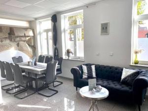 een woonkamer met een bank en een tafel en stoelen bij Hotel Mythos "Apartments" in Markgröningen
