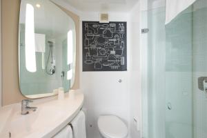 a bathroom with a toilet, sink, and shower at Ibis Sheffield City in Sheffield