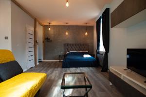een woonkamer met een bed en een tafel bij Apartament Antresola Fabryczna in Zielona Góra