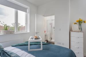 um quarto branco com uma cama e uma mesa em Luxury Serviced Apartments Stevenage, Hertfordshire em Stevenage