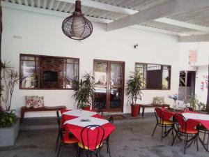 a restaurant with red tables and chairs in a room at HOTEL POUSADA PARAÍSO in Itapevy