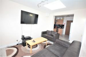 a living room with a couch and a table at London Deluxe 6 Bedroom House in Dagenham