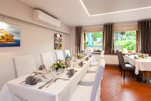 a dining room with white tables and white chairs at Landgasthof Tönnes in Wipperfürth