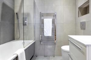 a bathroom with a shower with a tub and a toilet at Kenham Place I 1 bedroom apartment - Private Parking! in Bristol