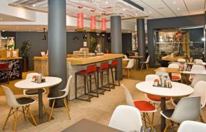 um restaurante com mesas e cadeiras e um bar em Ibis Sheffield City em Sheffield