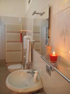 a bathroom with a sink and a mirror and a candle at B&B Casa Santina in Bologna