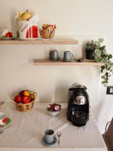 a tea kettle on a counter with a basket of fruit at B&B Casa Santina in Bologna