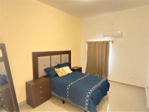 um quarto com uma cama com um edredão azul em Casa nueva recien equipada y completa. em Chihuahua