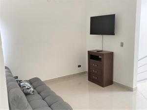 uma sala de estar com um sofá e uma televisão de ecrã plano em Casa nueva recien equipada y completa. em Chihuahua