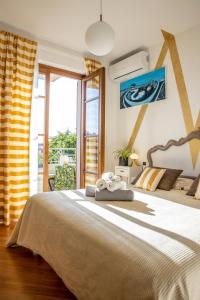 une chambre avec un grand lit et une grande fenêtre dans l'établissement La Stagione dell'Arte B&B, à Stiava 41 autres photos