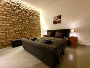 sypialnia z kanapą i kamienną ścianą w obiekcie Sam's Cottage Suite w mieście Niederweis