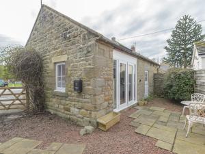 a stone house with a patio and a table at The Forge in Morpeth