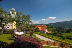 ein Haus mit einem Tisch und Stühlen im Hof in der Unterkunft Ferienwohnungen Perhofer in Birkfeld