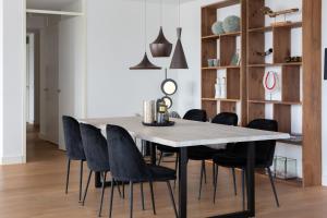 ein Esszimmer mit einem Tisch und schwarzen Stühlen in der Unterkunft BizStay Harbour I Scheveningen Apartments in Scheveningen