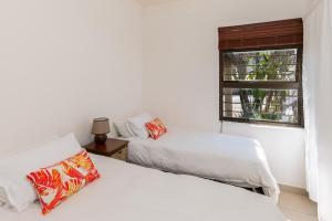 two beds in a room with a window at Boulder Bay 4 in Ballito