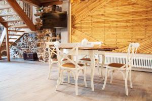 uma sala de jantar com uma mesa branca e cadeiras em A Forxa Casa Ferrador Ribeira Sacra em Sober