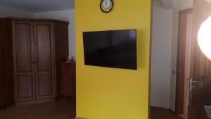 a tv on a yellow wall in a room at Ramresort Apartment in Birštonas
