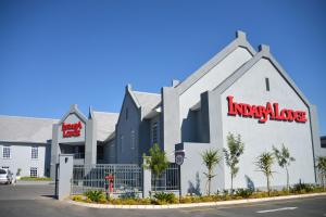 a large white building with a red sign on it at Indaba Lodge Gaborone in Gaborone