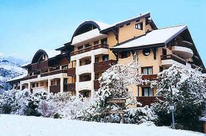 un grand bâtiment avec de la neige au sol dans l'établissement Les Jardins Alpins - Apartment, à Saint-Gervais-les-Bains