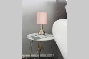 a lamp on a small table next to a bed at Stay Newbiggin-By-The-Sea in Woodhorn