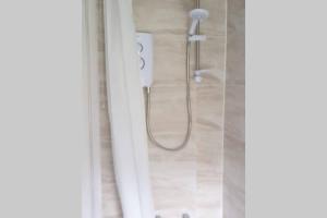 a shower in a bathroom with a glass door at Stay Newbiggin-By-The-Sea in Woodhorn