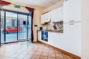 a kitchen with white cabinets and a red car outside at Lovely Studio Trastevere in Rome