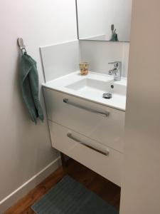 een badkamer met een witte wastafel en een spiegel bij La maison de Vallières in Clermont-Ferrand