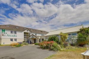 un bâtiment avec un panneau sur son côté dans l'établissement Hôtel Arcadia, à Lannion