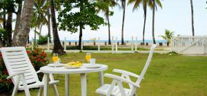 a table with a plate of fruit and two chairs at Villa directly on the beach, las Ballenas in Las Terrenas