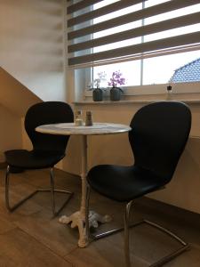 two chairs and a table in a room with a window at H&E Apartments in Steinheim