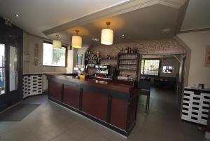 a large bar in a restaurant with a counter at Hôtel Le Bellevue - Paris Porte d'Orléans in Cachan