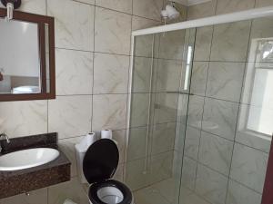 a bathroom with a shower and a toilet and a sink at Iria's Hotel in Timbó