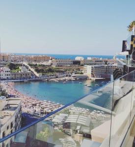 a view of a beach and the ocean from a building at Holiday Inn Express - Malta, an IHG Hotel in St. Julianʼs