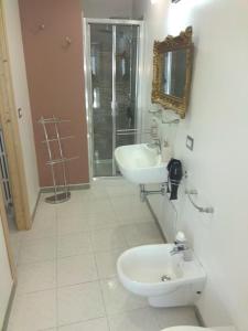a bathroom with a sink and a toilet and a mirror at PEDRA HOUSE in Catania